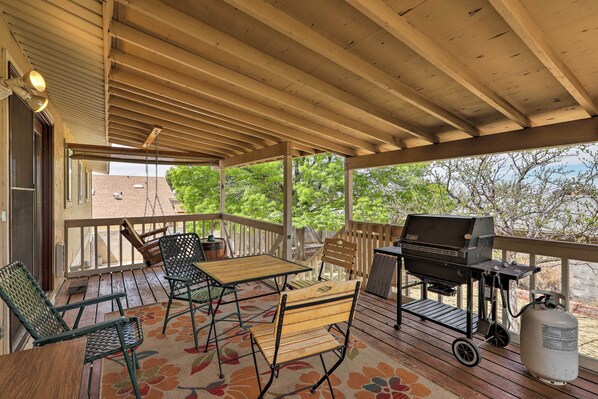 A covered outdoor deck with a grill, seating, and a view of trees. - Walk to Rim View Trail: Page Home w/ Deck & Yard (Page)