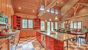 A spacious kitchen with wooden cabinets, a large island, and a checkered floor.