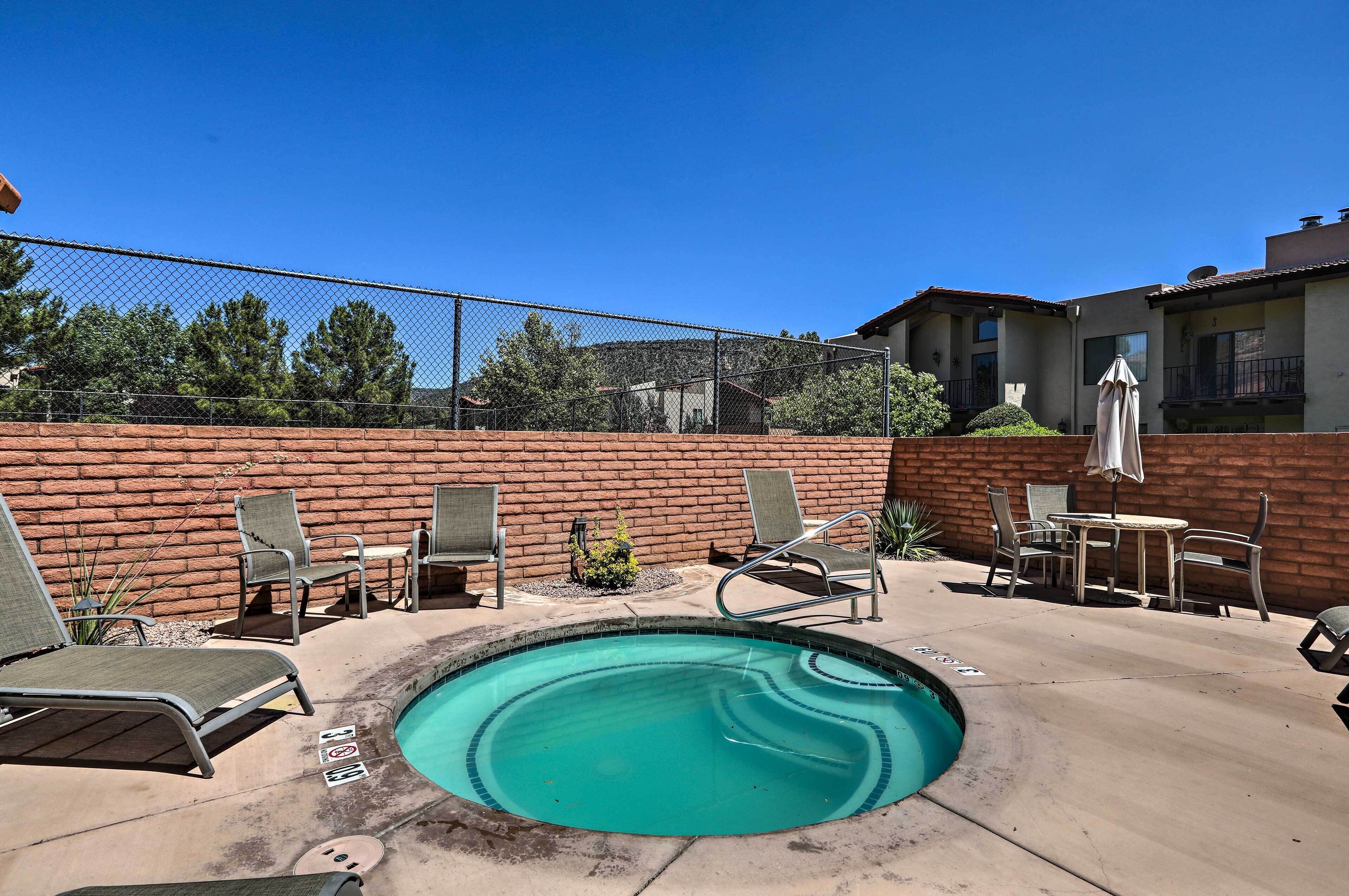 A swimming pool with lounge chairs and a brick wall.