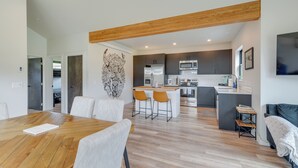 Une cuisine moderne avec des meubles de couleur sombre, un îlot central et un four à micro-ondes.