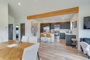 Una cocina moderna con armarios oscuros, una isla central y un microondas.