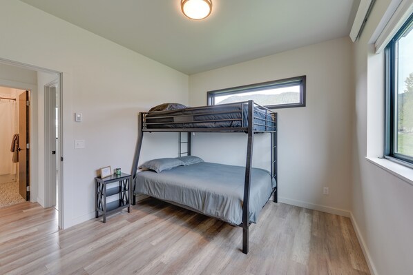 A bunk bed in a room with wooden flooring, a small table, and a window with a view. - Quiet Alpine Hideaway w/ Panoramic Mountain Views! (Alpine)