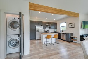Una cocina moderna con una isla central, electrodomésticos integrados y techo de madera.