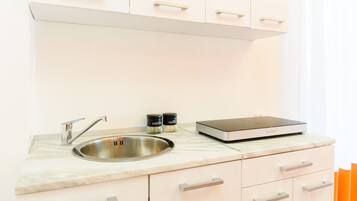 A modern kitchen with a stainless steel sink, a scale, and two spice containers.