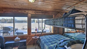 A cabin with bunk beds, a desk, and a window overlooking a snowy landscape. - New Hampshire Home w/ Private Beach, Dock & Rafts! (Center Barnstead)