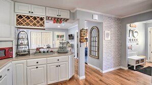 A kitchen with white cabinetry, a red microwave, and a wine rack. - New Hampshire Home w/ Private Beach, Dock & Rafts! (Center Barnstead)