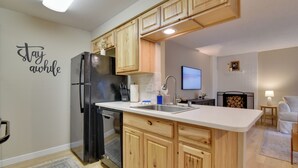 A modern kitchen with wooden cabinets, a stainless steel refrigerator, a built-in dishwasher, and a white countertop. - Lovely Vancouver Retreat w/ Home Gym! (Vancouver)