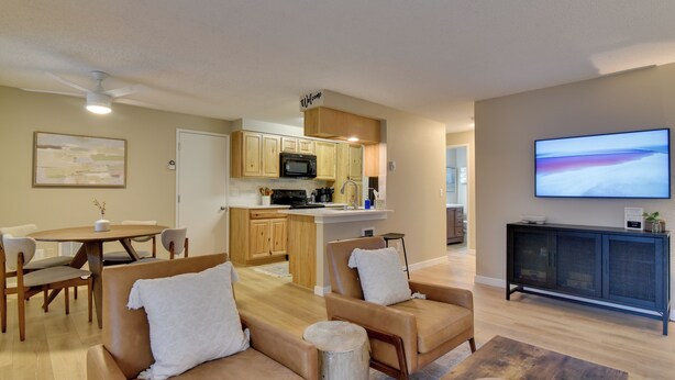 A modern living room with a sofa, coffee table, and a TV. - Lovely Vancouver Retreat w/ Home Gym! (Vancouver)