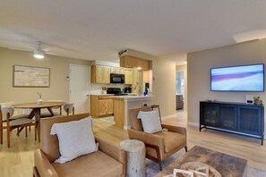 Ein modernes Wohnzimmer mit einer Couch, einem Couchtisch und einem Fernseher.