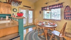 A dining area with a wooden table, chairs, and a red bowl on the counter. - Rustic Cabin w/ Deck ~ 4 Mi to Old Town Flagstaff! (Flagstaff)