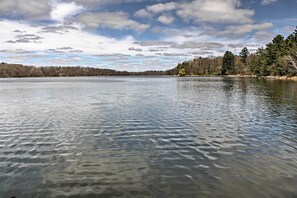 A calm lake with clear water, surrounded by trees and a cloudy sky. - Cozy Balsam Lake Home: Deck, Private Dock + Kayaks (Balsam Lake)