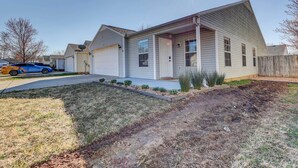 A single-story house with a garage, a front porch, and a small front yard with landscaping.