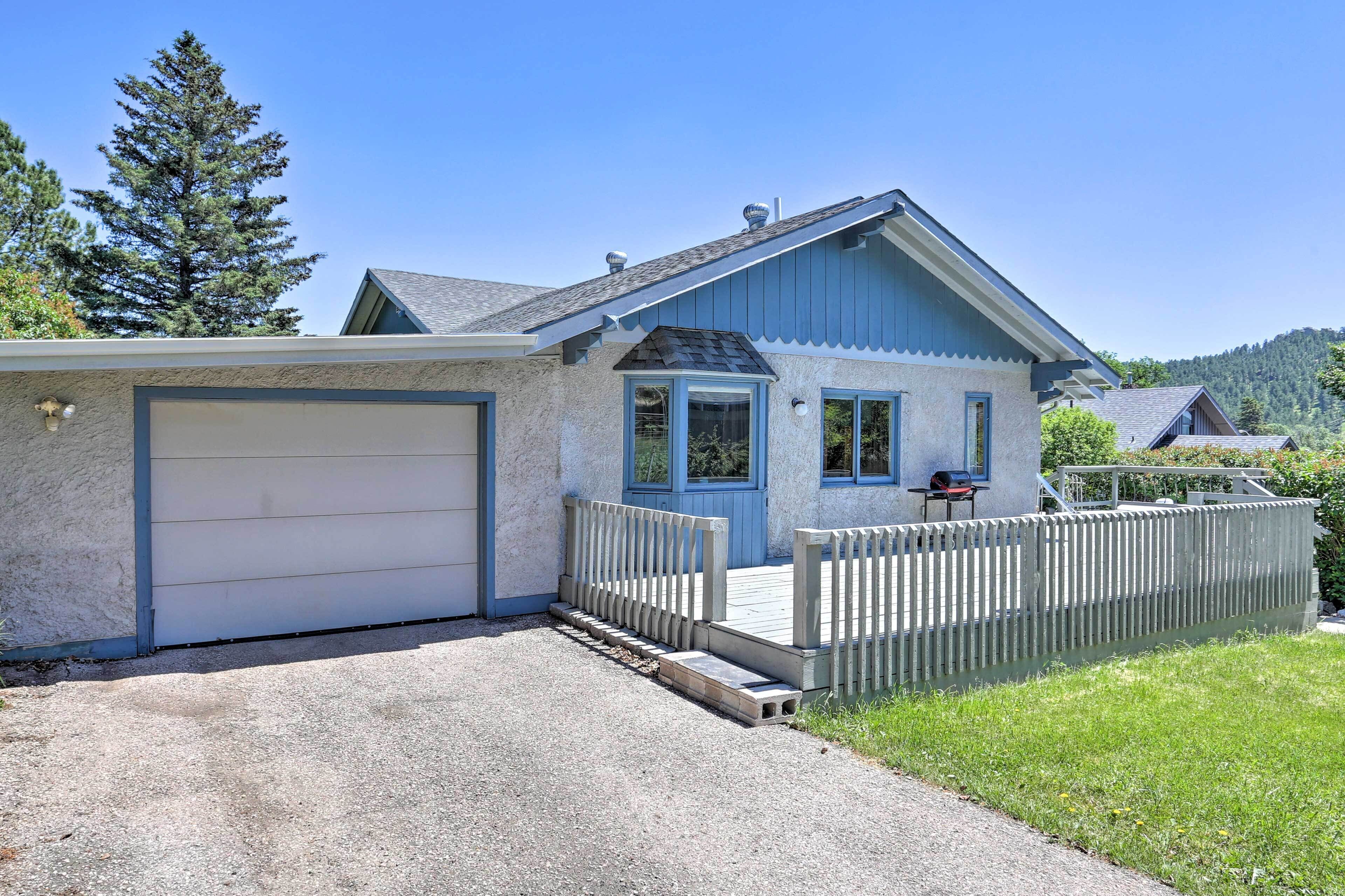 A single-story house with a garage, a small porch, and a wooden fence.