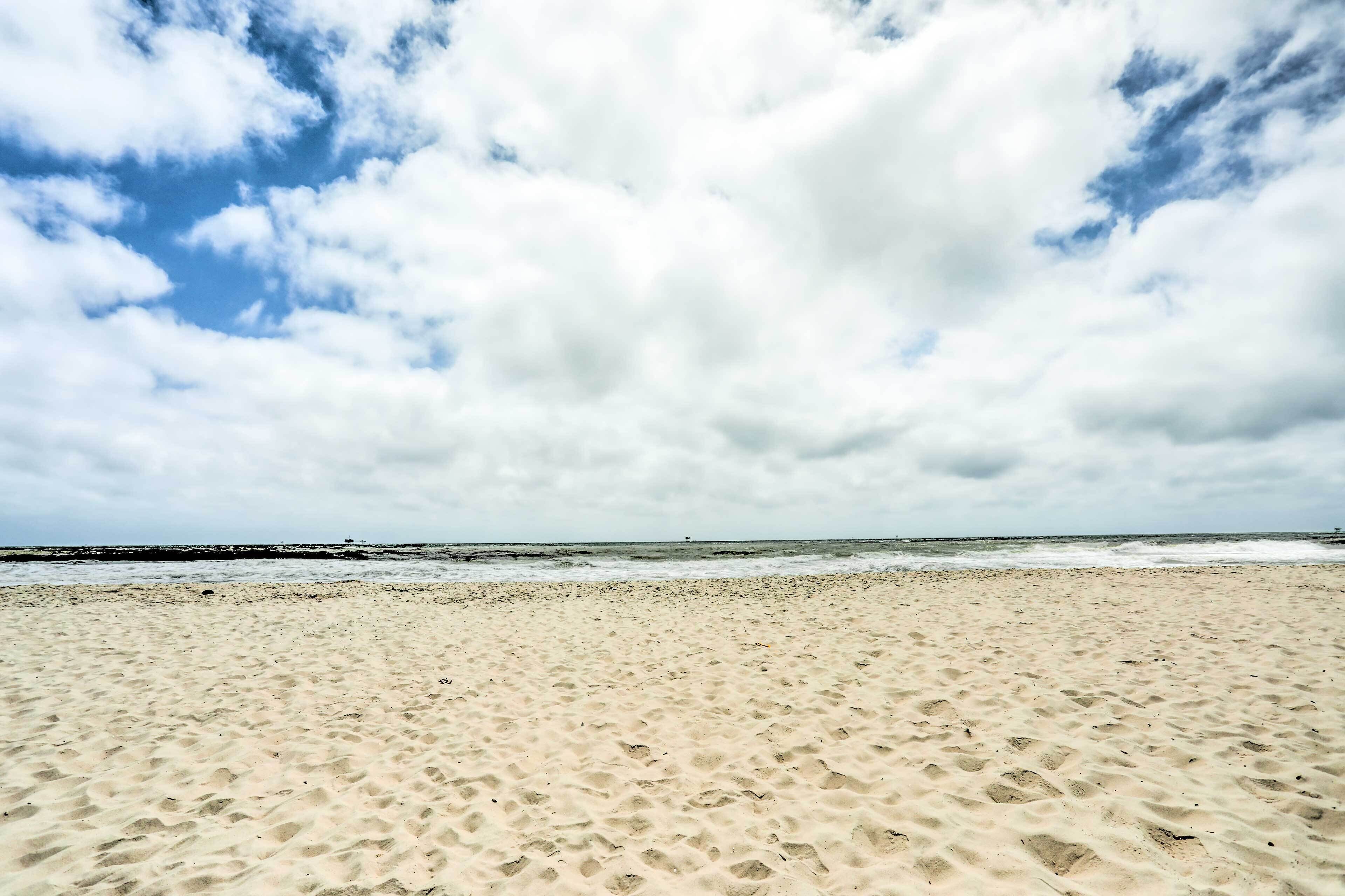 A sandy beach with footprints leading to the water.