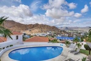 A swimming pool with a view of a town and mountains in the background. - Chic Cabo Condo - Walk to Marina & Downtown! (Cabo San Lucas)