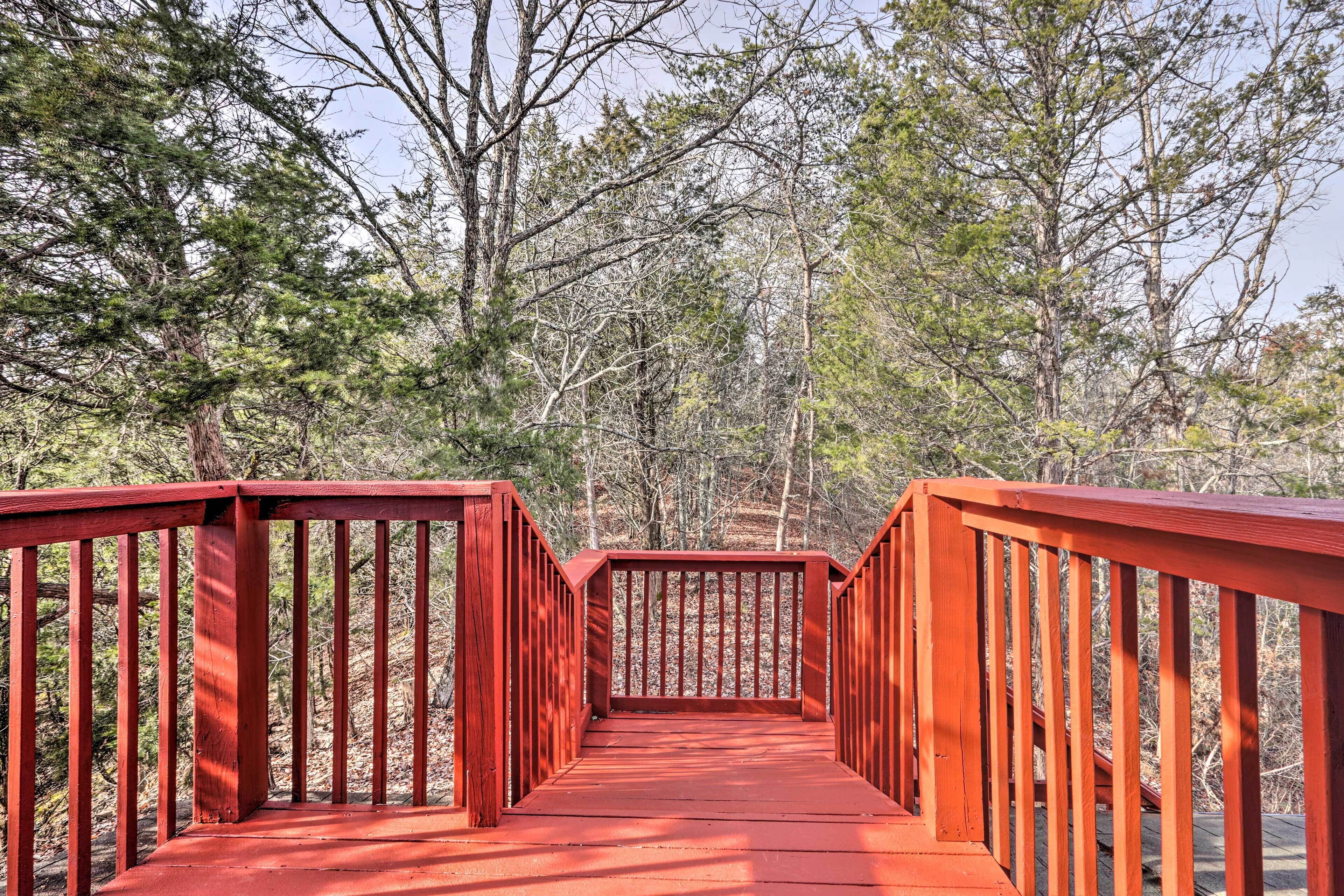 A red wooden bridge in a forested area.
