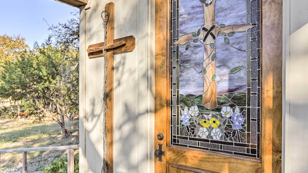 Una puerta de madera con un vitral que representa un árbol y flores.