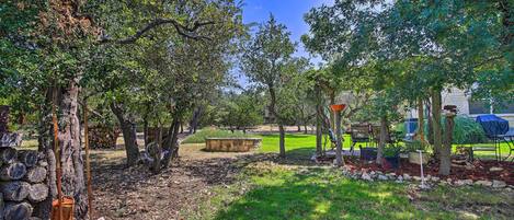 A park with trees, a stone wall, and a picnic area.