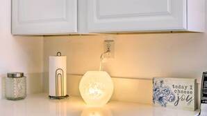 A kitchen counter with a white candle, a lit candle holder, a decorative sign, and a power outlet. - Cozy Lompoc Studio w/ Patio ~ 9 Mi to Beach (Lompoc)