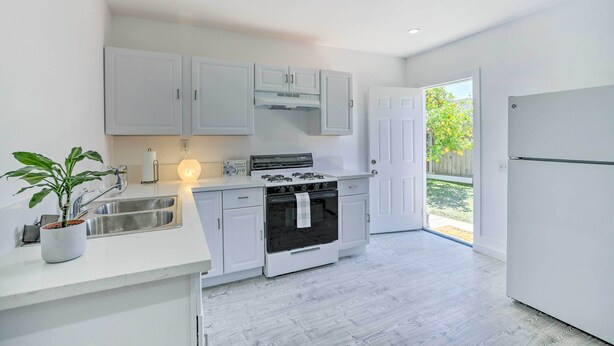 A modern kitchen with white cabinetry, a built-in oven, and a stainless steel sink. - Cozy Lompoc Studio w/ Patio ~ 9 Mi to Beach (Lompoc)