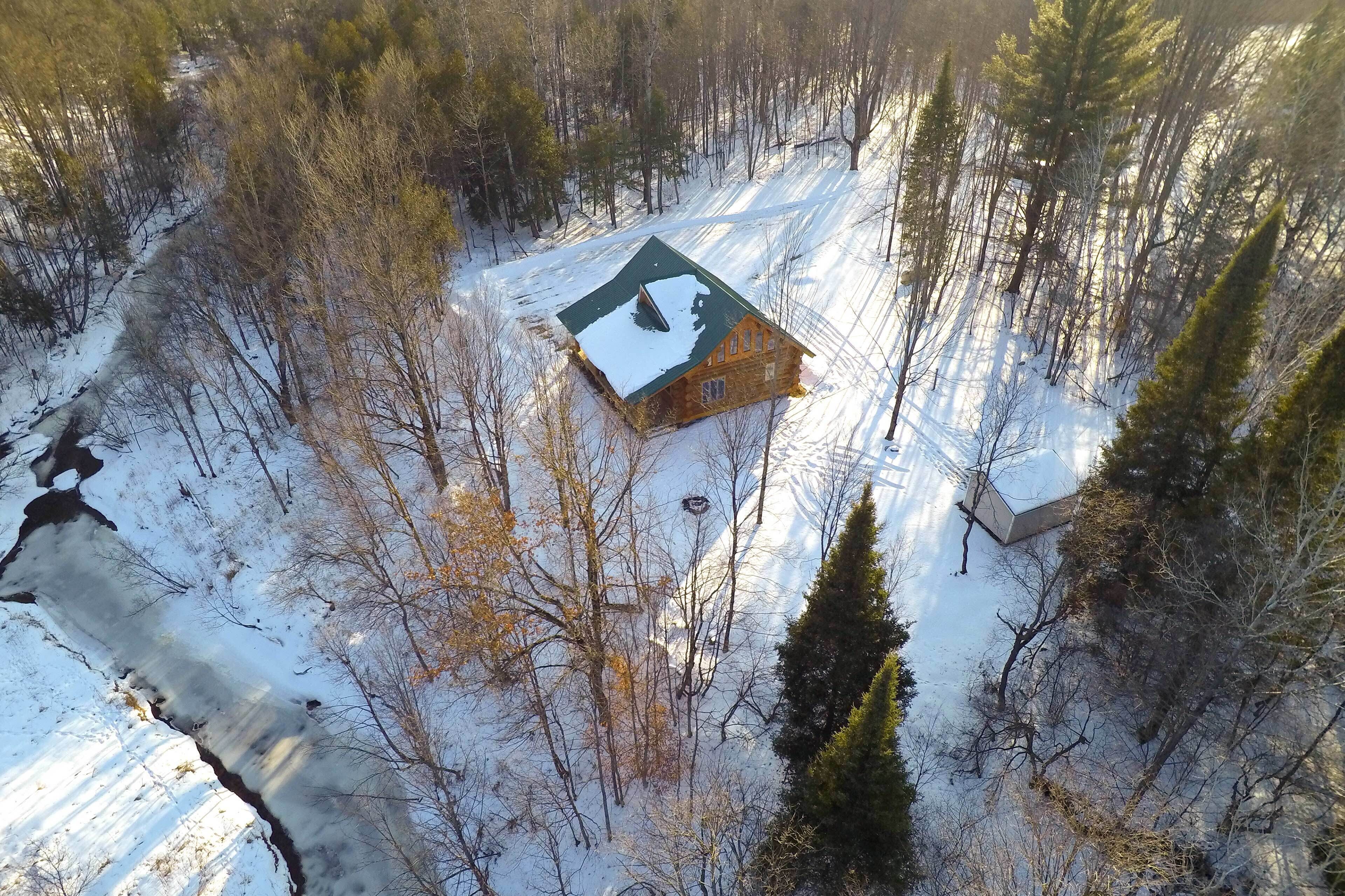 Une cabane en bois entourée d’une forêt enneigée.