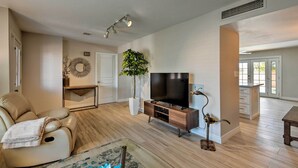 A modern living room with a sofa, TV, and decorative items. - 3 Mi to Asu: Tempe Getaway w/ Heated Pool (Tempe)
