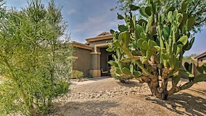 A desert landscape with a large cactus and a building with a tiled roof. - Game Room, Fenced Yard: Estrella Oasis in Goodyear (Goodyear)