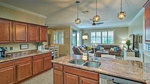 A spacious kitchen with granite countertops, wooden cabinets, and a built-in dishwasher. - Game Room, Fenced Yard: Estrella Oasis in Goodyear (Goodyear)