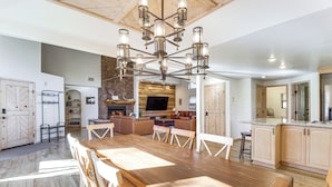 A spacious kitchen with a large wooden table and modern lighting fixtures. - Hot Tub: 'ponderosa Paradise' Overgaard Cabin (Overgaard)