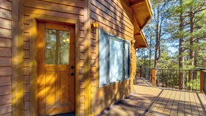 A wooden cabin with a deck, a door, and windows. - Hot Tub: 'ponderosa Paradise' Overgaard Cabin (Overgaard)