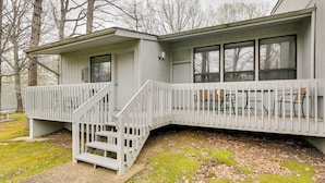 A two-story building with a white exterior, a covered porch with a white railing, and a staircase leading to the upper level. - Crossville Golfer's Haven: 5 On-site Courses! (Crossville)