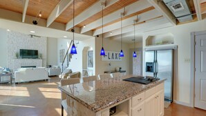 A spacious kitchen with granite countertops, a built-in refrigerator, and pendant lighting. - Waterfront Granbury House w/ Deck & Private Dock! (Granbury)