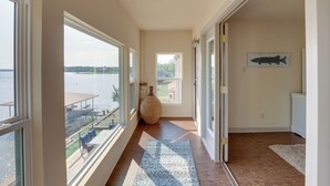 A hallway with large windows, a rug, a vase, and a fish wall art. - Waterfront Granbury House w/ Deck & Private Dock! (Granbury)