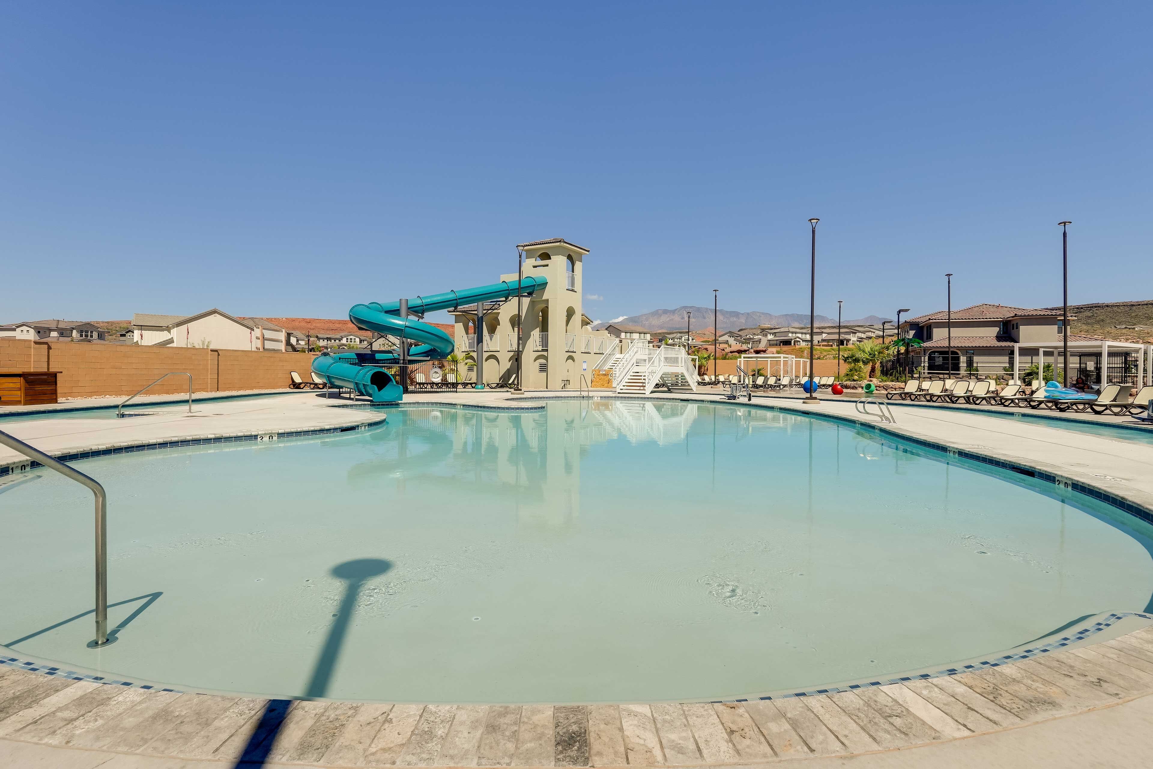 A swimming pool with a water slide, a tower, and a view of mountains.