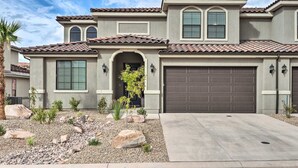 A two-story house with a tiled roof, a garage, and a landscaped front yard with rocks and plants. - Lazy River, Arcade & Pickleball in Washington! (Washington)