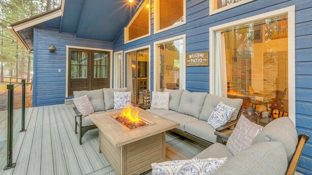 A blue wooden deck with a fire feature, grey sofas, and a 'Welcome Patio' sign. - Mtn-view Cabin w/ Game Room & Deck in Flagstaff (Flagstaff)