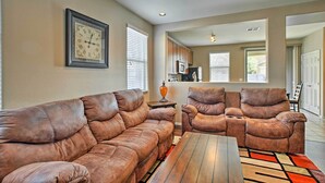 A living room with a brown leather sofa, a wooden coffee table, and a ceiling fan. - Dog-friendly Arizona Retreat w/ Patio & Grill! (Gilbert)