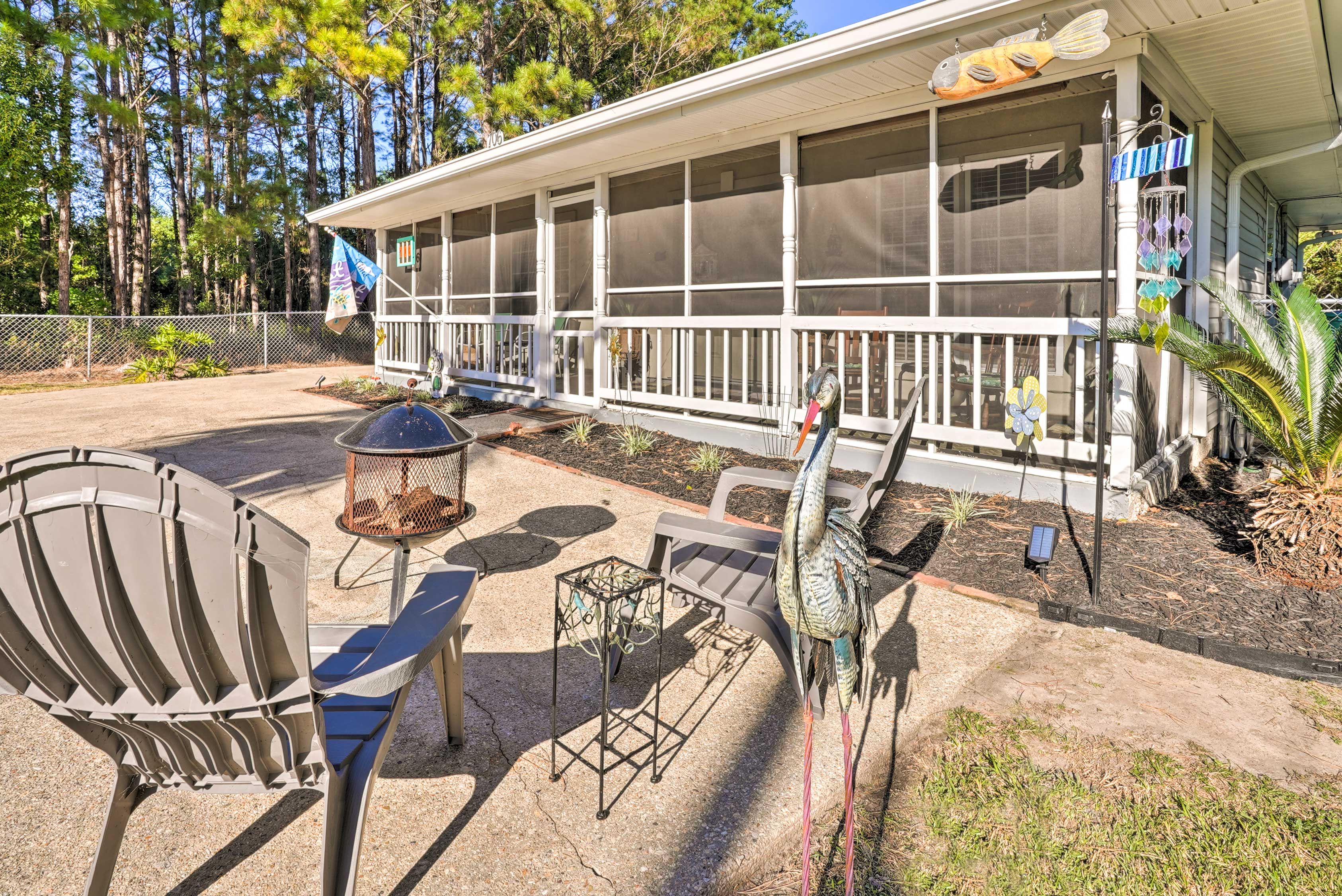 A covered outdoor area with a white building, a bird feeder, and a chair.