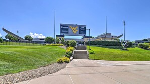 A stadium entrance with a large sign, steps leading up to the entrance, and well-maintained grassy areas. - Morgantown Home w/ Patio: Near WVU Football! (Morgantown)