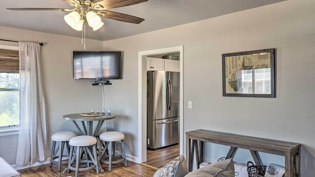A modern kitchen with a stainless steel refrigerator, a ceiling fan, and a flat-screen TV mounted on the wall. - Morgantown Home w/ Patio: Near WVU Football! (Morgantown)