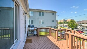 A residential deck with a barbecue grill, a wooden railing, and a view of a street with cars and buildings. - Morgantown Home w/ Patio: Near WVU Football! (Morgantown)