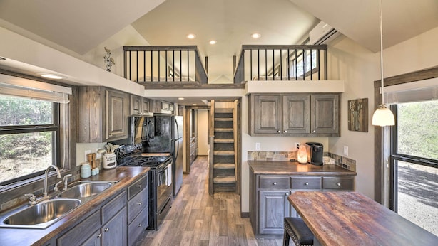 A modern kitchen with wooden cabinets, stainless steel appliances, and a central island. - Roomy Pagosa Springs Tiny Cabin: 1 Mi to Downtown (Pagosa Springs)