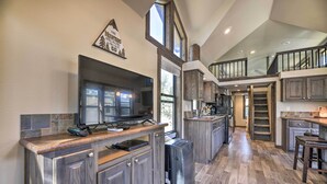 A spacious kitchen with dark wood cabinets, a large island, and a built-in oven. - Roomy Pagosa Springs Tiny Cabin: 1 Mi to Downtown (Pagosa Springs)
