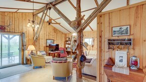 A rustic wooden interior with a sofa, armchair, and a dining table. - Black Hills Vacation Rental 25 Mi to Mt Rushmore! (Hermosa)