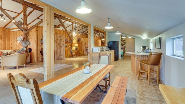A spacious kitchen with wooden beams, a long dining table, and bar seating. - Black Hills Vacation Rental 25 Mi to Mt Rushmore! (Hermosa)