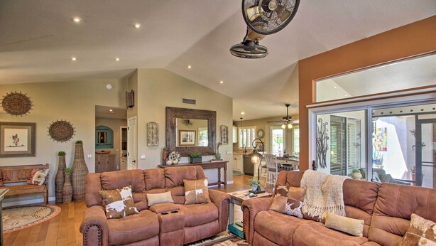 A spacious living room with a brown leather sofa set, a coffee table with decorative items, and a large mirror reflecting the room. - AZ Home w/ Resort-style Amenities & Mtn View! (Saddlebrooke)