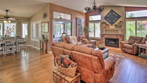 A spacious living room with a fireplace, comfortable seating, and large windows. - AZ Home w/ Resort-style Amenities & Mtn View! (Saddlebrooke)