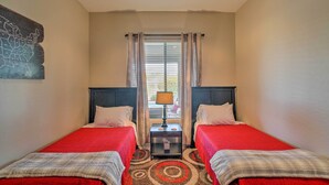 A room with two beds, a small table with a lamp, a window with curtains, and a wall map. - Scottsdale Home - Mtn Views, Pool, Near Westworld! (Scottsdale)