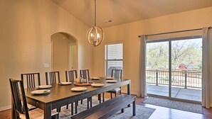 A dining room with a large table, chairs, a bench, a chandelier, and a view through a sliding glass door to an outdoor area. - 'mount Elden Retreat:' 4 Mi to Dtwn Flagstaff (Flagstaff)