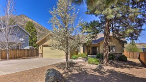 A residential area with two houses, one with a garage and the other with a front porch. There are trees, a large rock, and a clear sky. - 'mount Elden Retreat:' 4 Mi to Dtwn Flagstaff (Flagstaff)